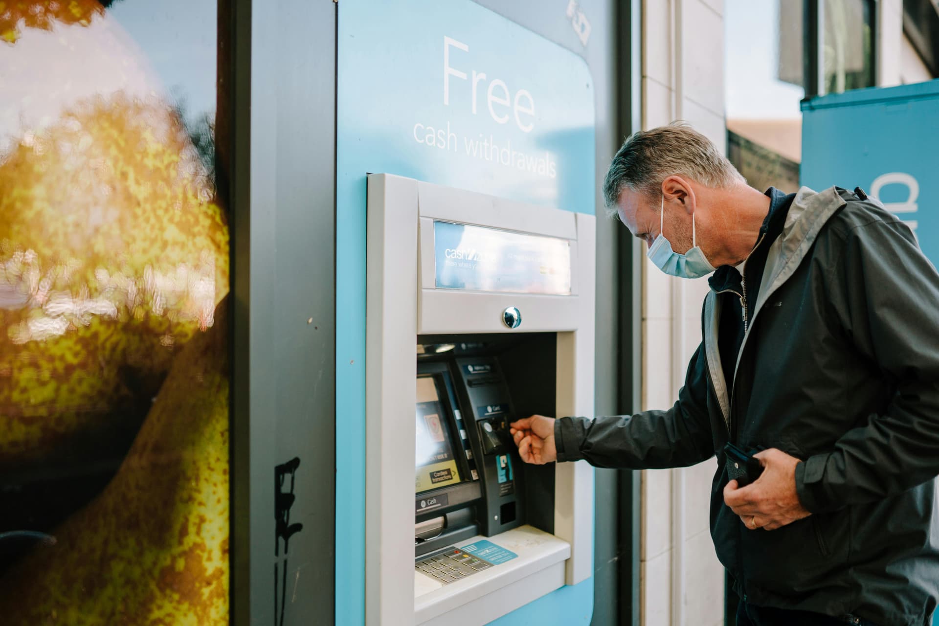 Person using ATM machine outdoors
